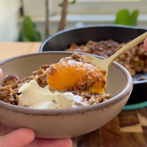 Bowl of Peach Crumble topped with yogurt