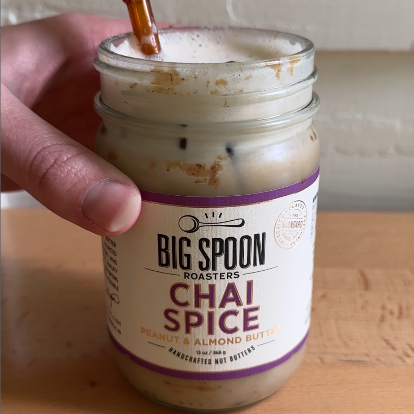 jar of Chai Spice nut butter filled with an iced latte and straw