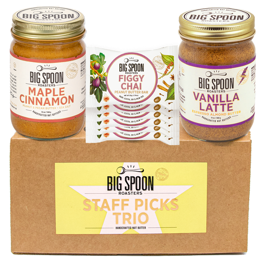 Big Spoon Roasters staff picks trio with jars of maple cinnamon, figgy chai bars, and vanilla latte on a cardboard box.