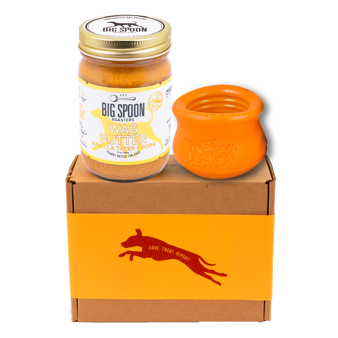 Jar of Vanilla Tater Wag Butter and an orange West Paw Toppl toy on top of a gift box