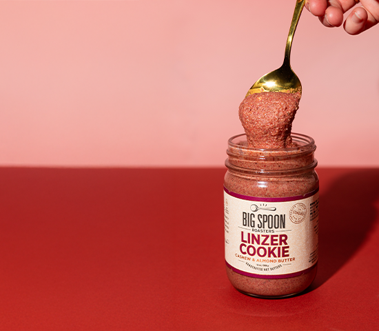 jar of Linzer Cookie Cashew & Almond Butter on a pink and red background