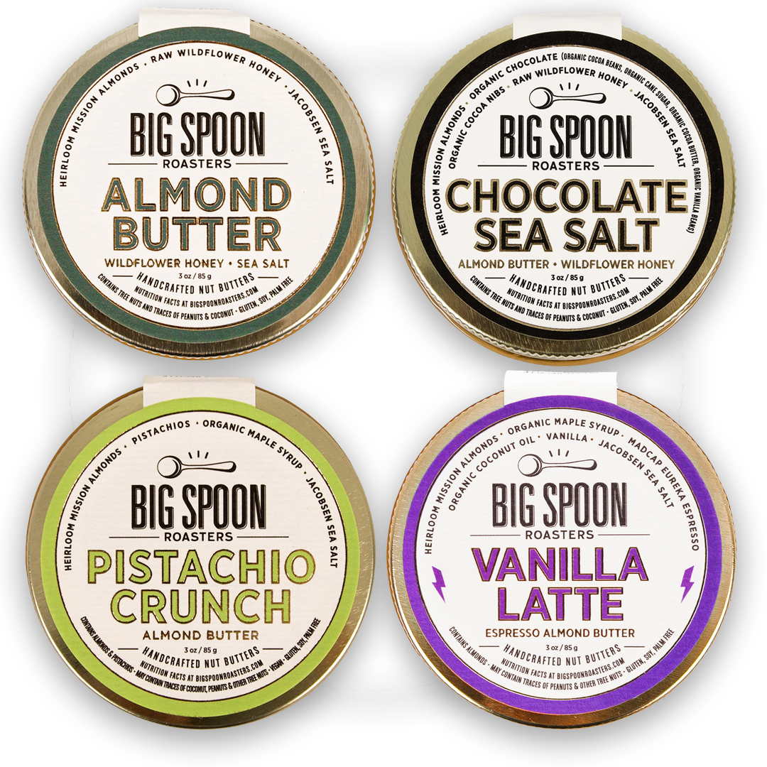Four containers of Big Spoon Roasters almond butter with different flavors on a white background.