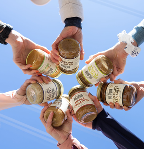 Seven people holding Big Spoon Roasters jars in a circle
